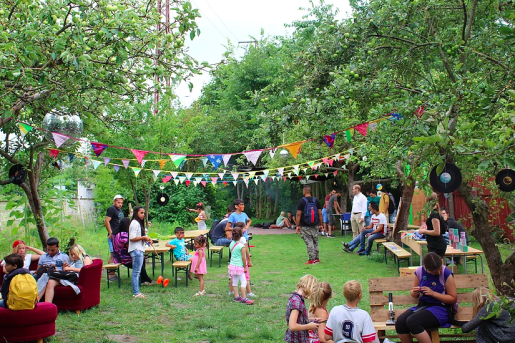 Verschiedene Menschen essen, trinken, reden im Garten