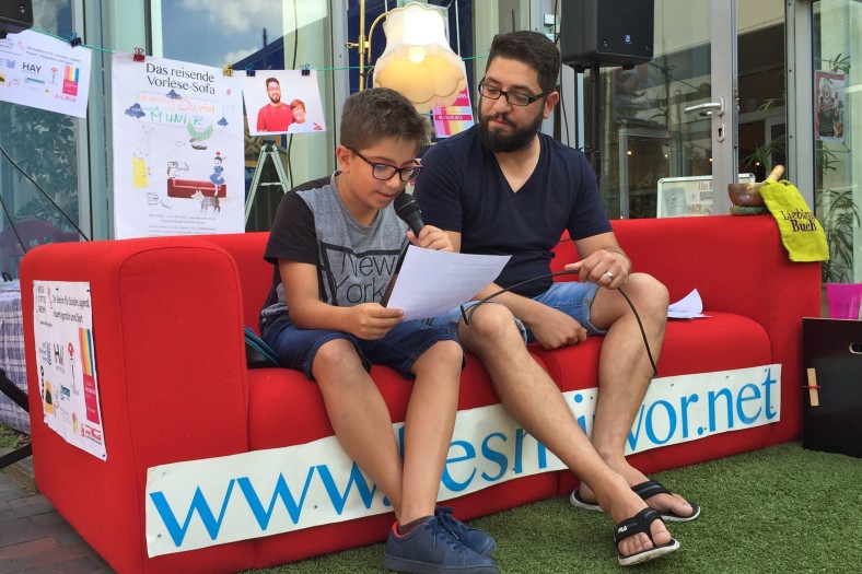 Vater und Sohn sitzen auf Sofa und lesen