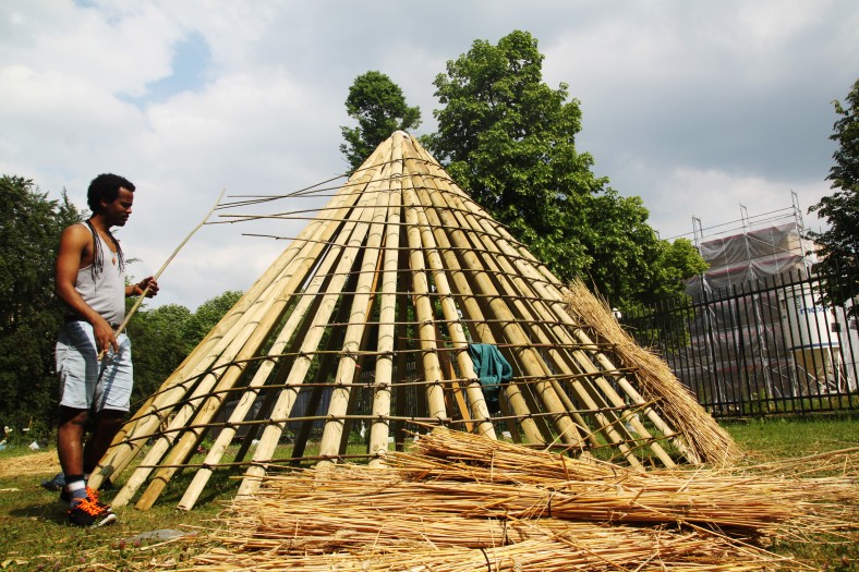 Mann baut ein Dach aus Holz und Bambus