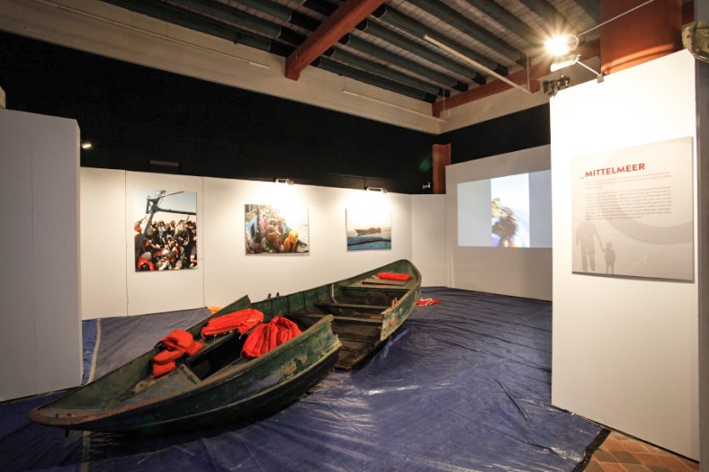 Ausstellungswände, in der Mitte eine Boot und Schwimmwesten