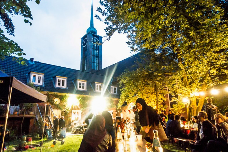 Verschiedene Menschen im Freien, am Tisch, essen, trinken, lachen reden