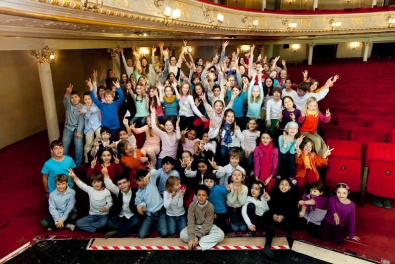 Verschiedene Kinder bei Gruppenfoto, lachen, strecken Hände in die Luft