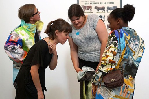 Mehrere Personen in einer Ausstellung, sie tragen teilweise sehr bunte Jacken und Jackets