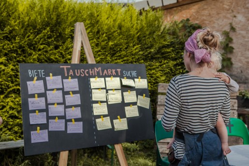 Person in einem Garten, betrachtet Infotafel