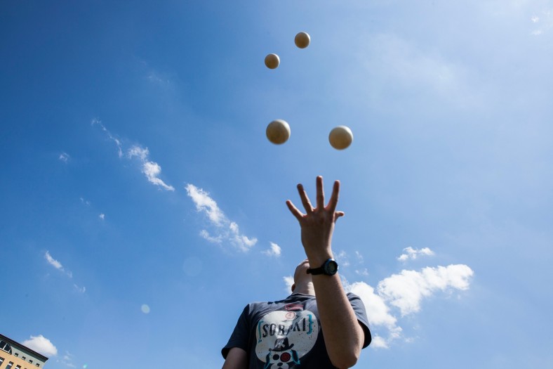 Eine Person jongliert mit mehreren Bällen